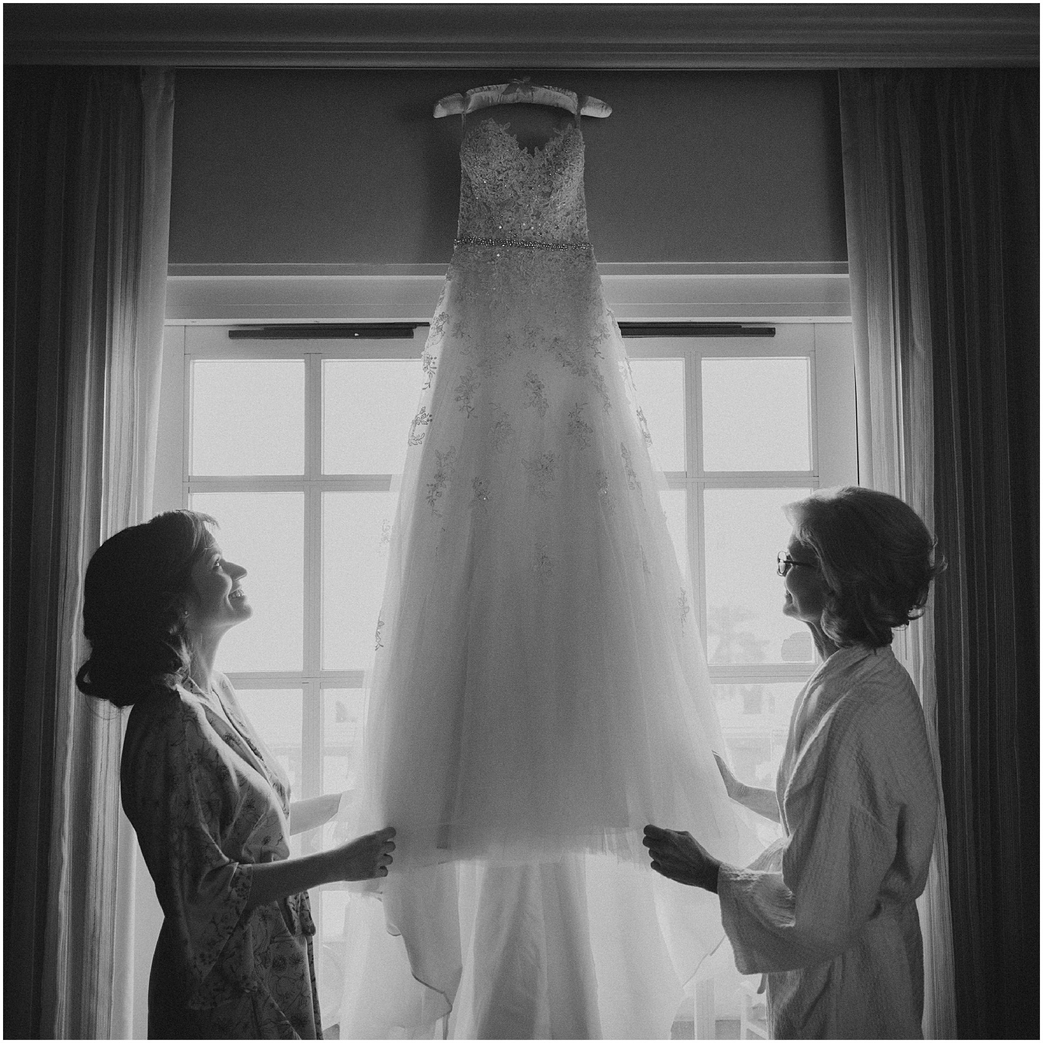 daughter and mother looking up at wedding dress