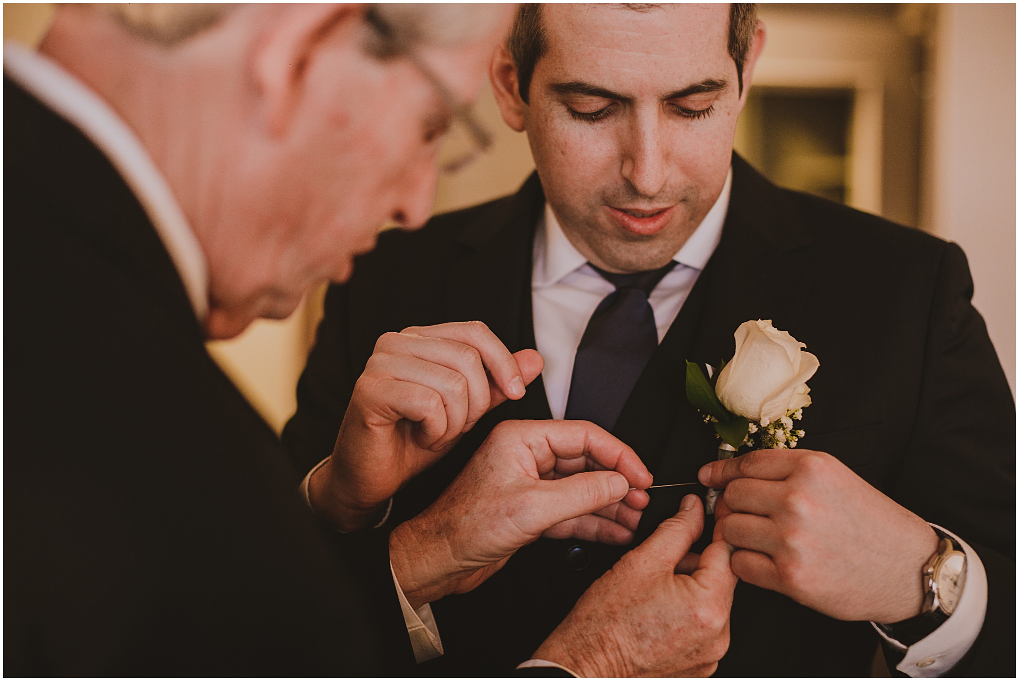 groom putting boutonnière