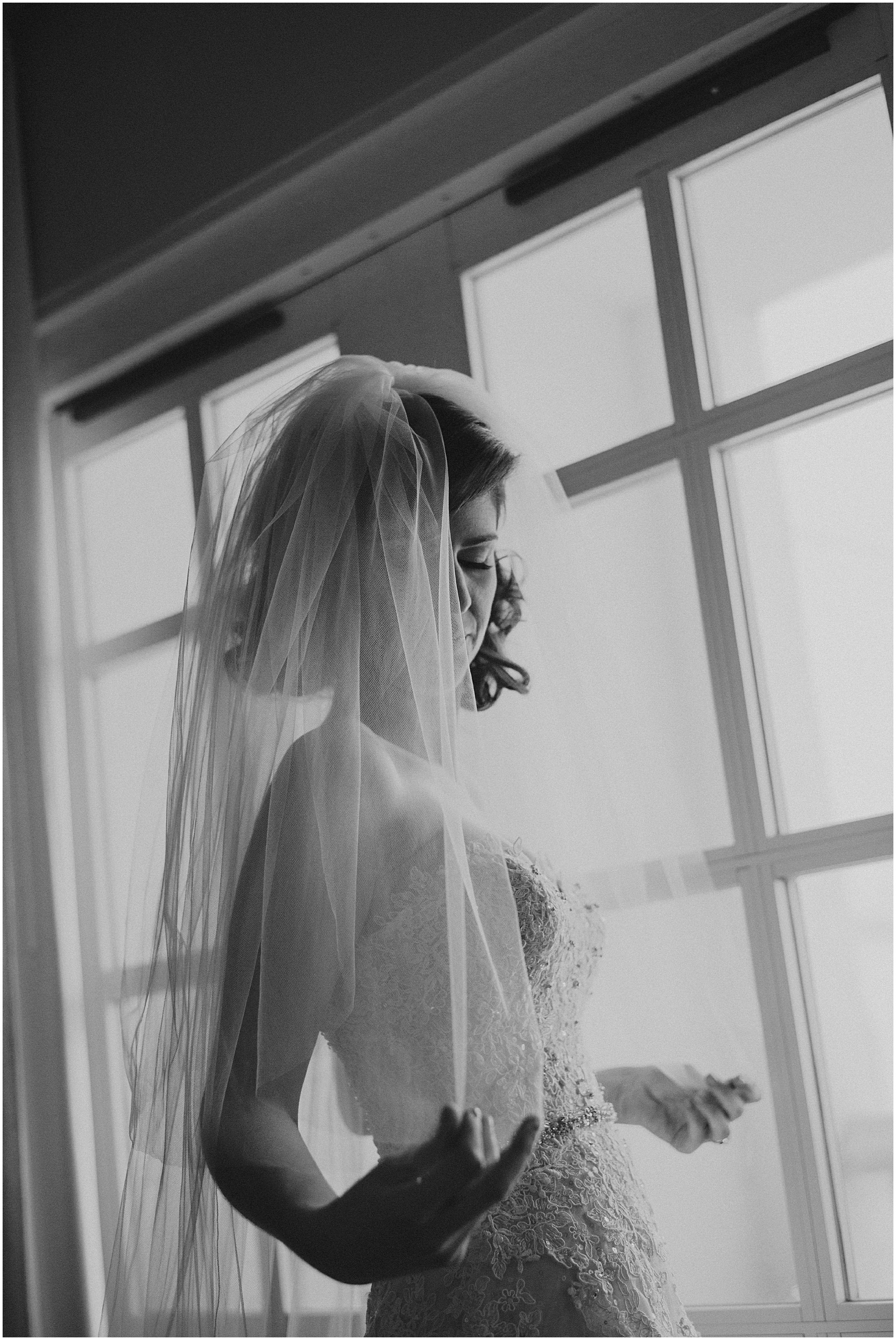 fine art black and white portrait of bride by window