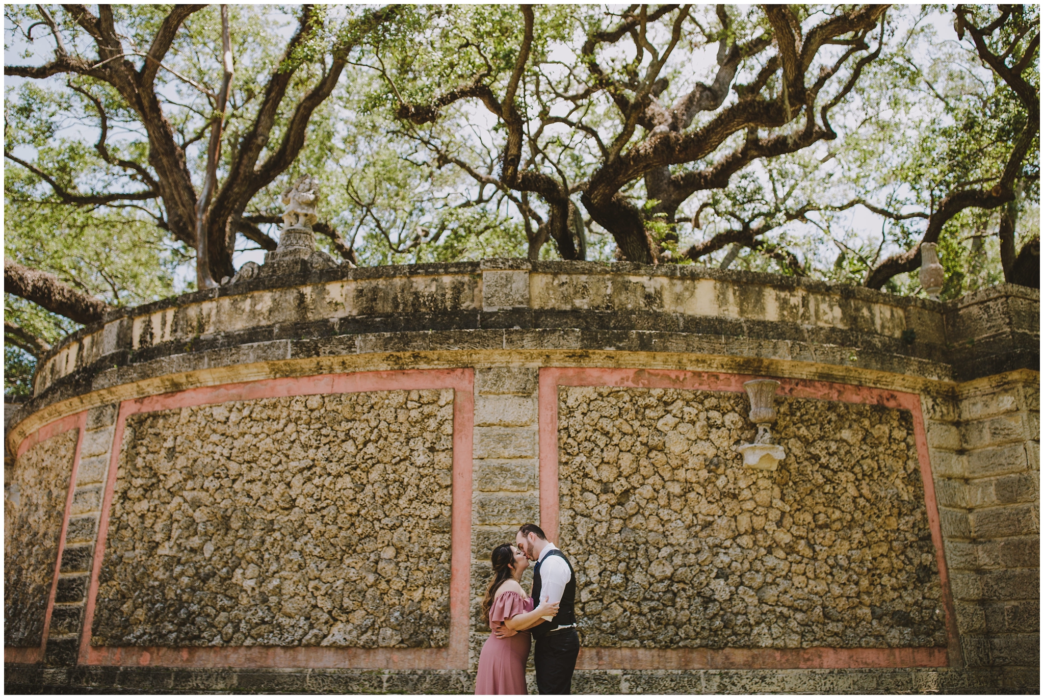 couple in front of giant limestone wall at vizcaya
