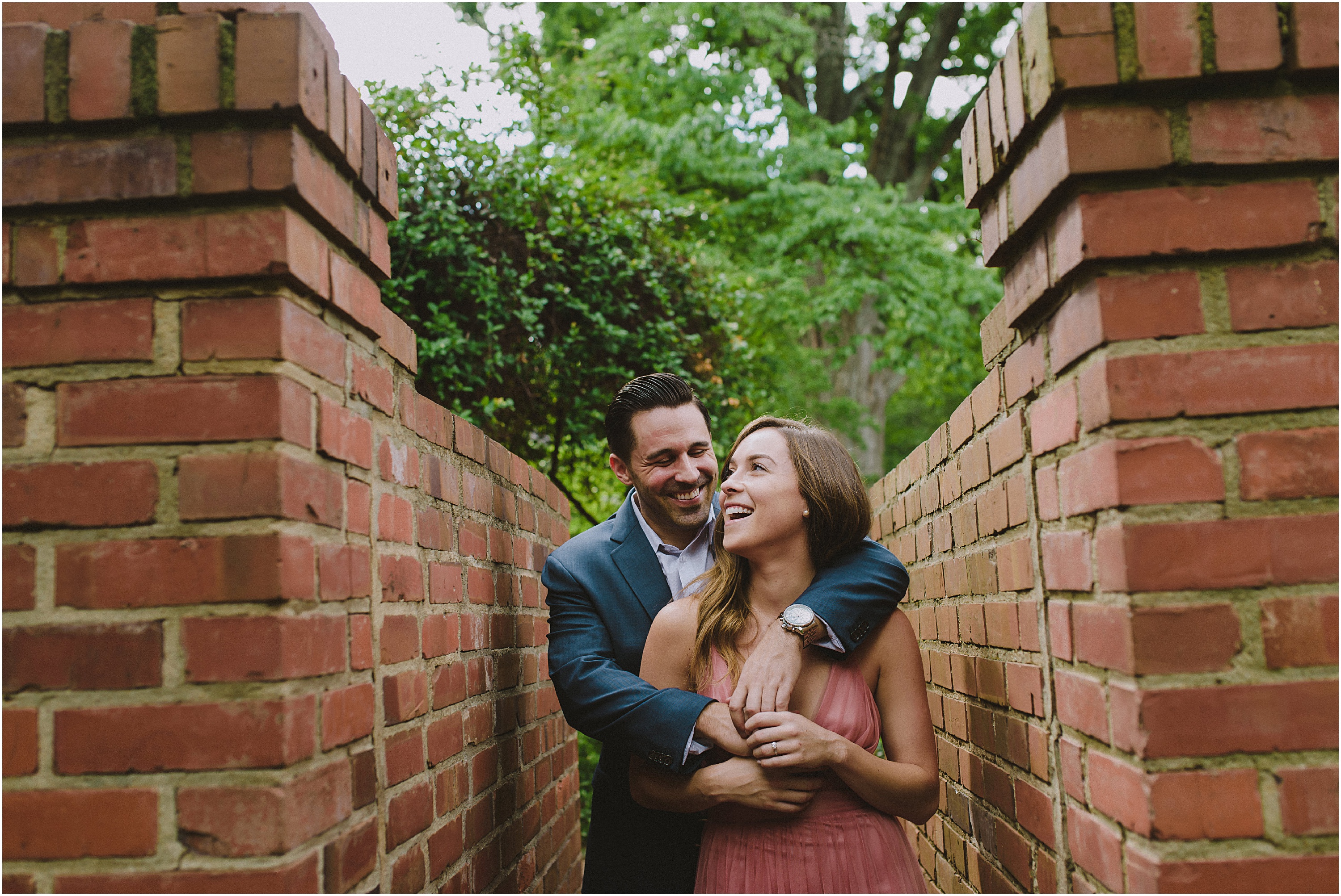 couple hugging between red brick walls