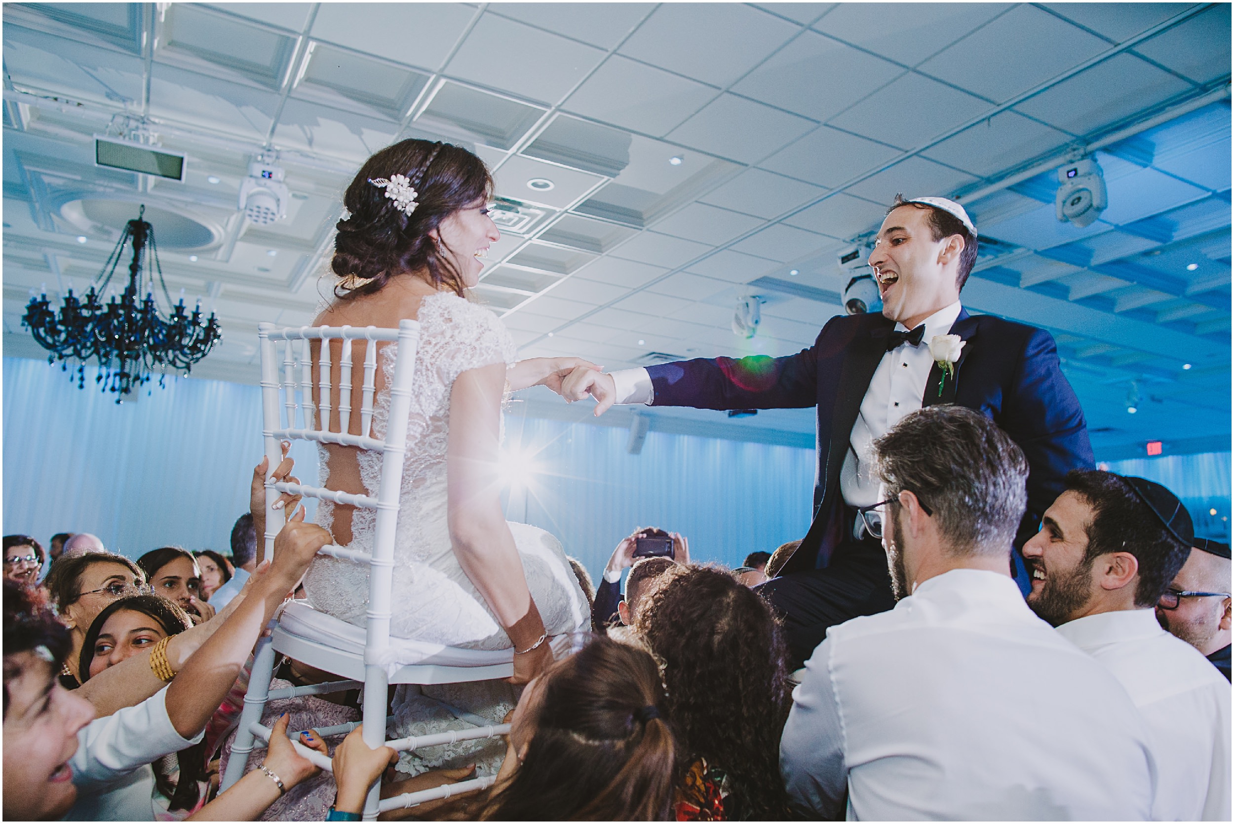 bride and groom on chairs during their hora at Lavan Venue