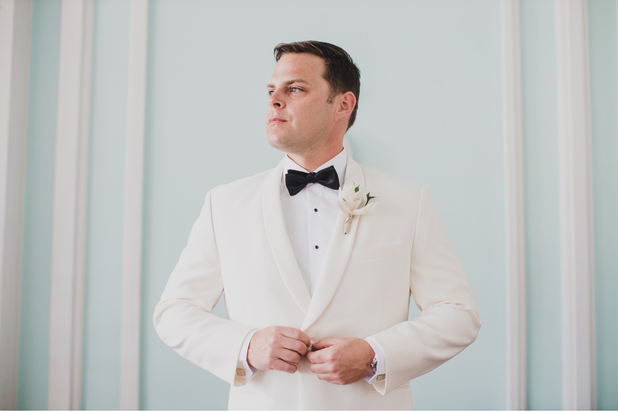 groom with white jacket black tie tuxedo