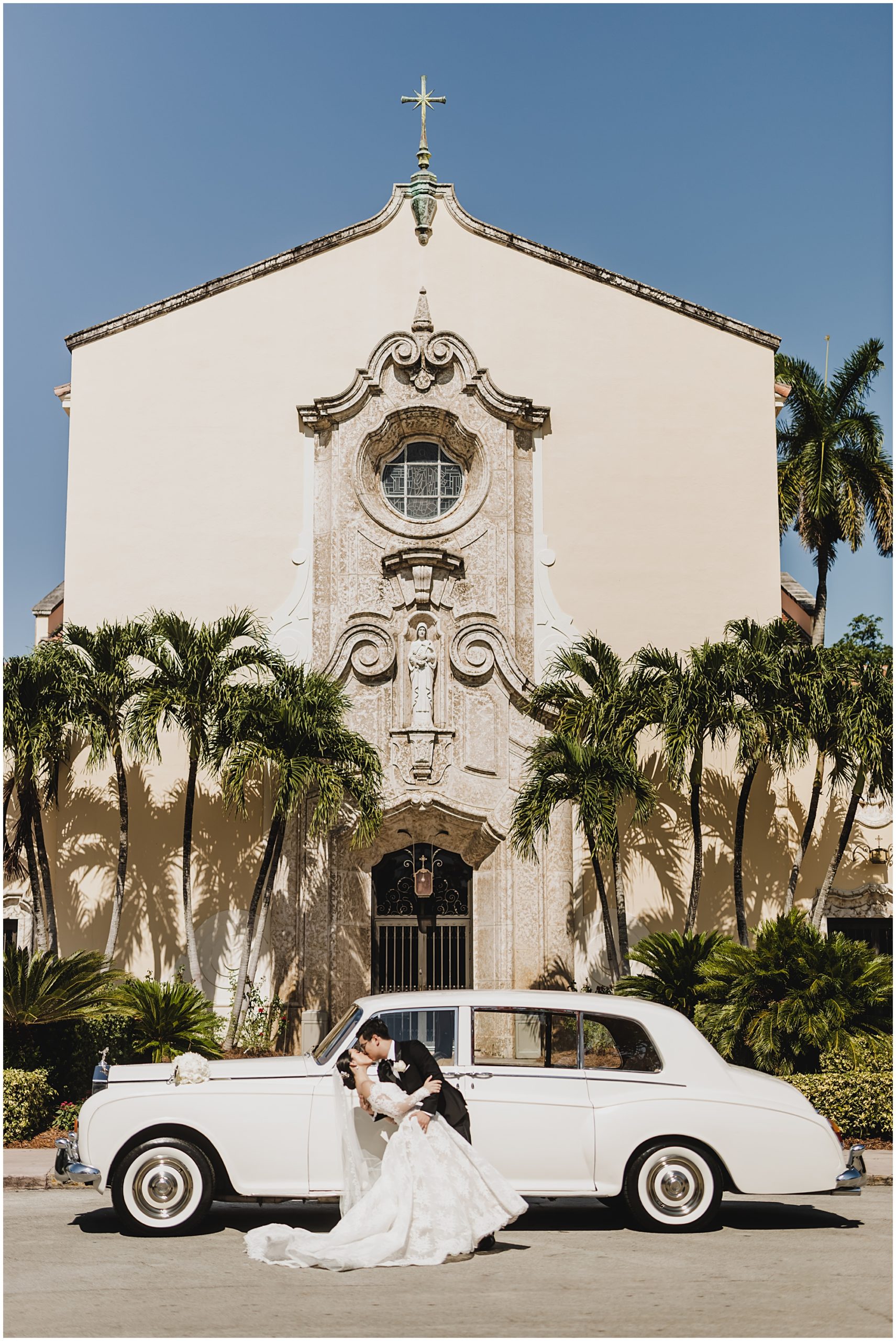 Couple posing in front of Church of the Little Flower and classic car.